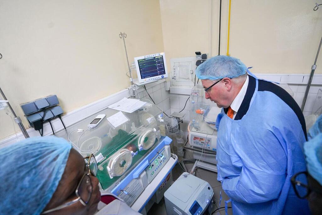 Le directeur exécutif adjoint de l'UNFPA, Andrew Saberton, vêtu d'une tenue médicale et d'un bonnet de protection, observe un incubateur dans une maternité d'un hôpital au Tchad.