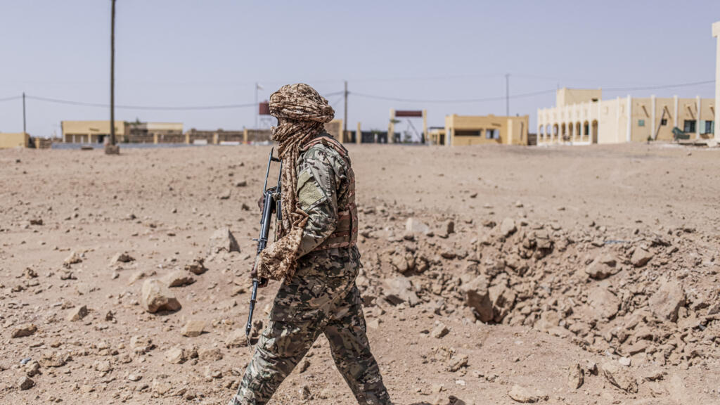 Un soldat malien inspecte un cratère de bombardement à Kidal, dans le nord du Mali, en mai 2026.